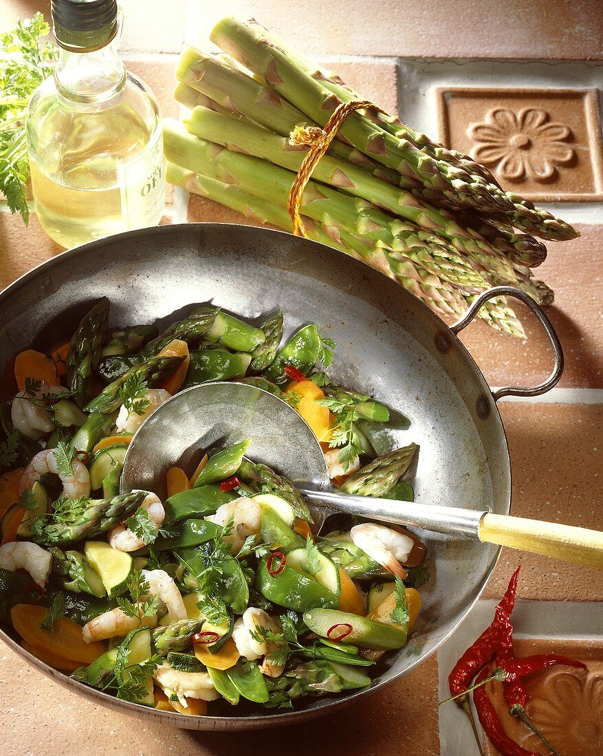 Green asparagus tips with mangetout & chili in wok
