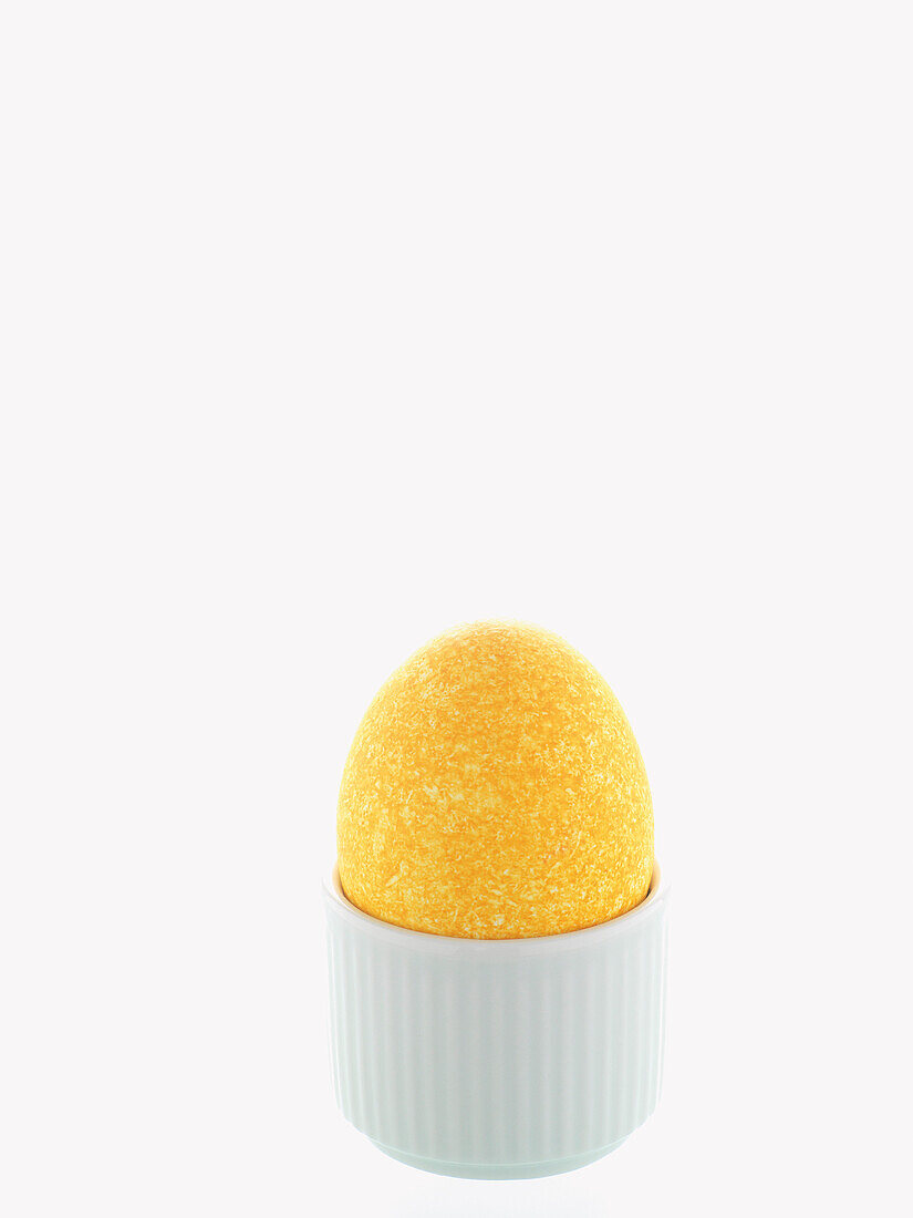 Gelbes Osterei in weißem Eierbecher