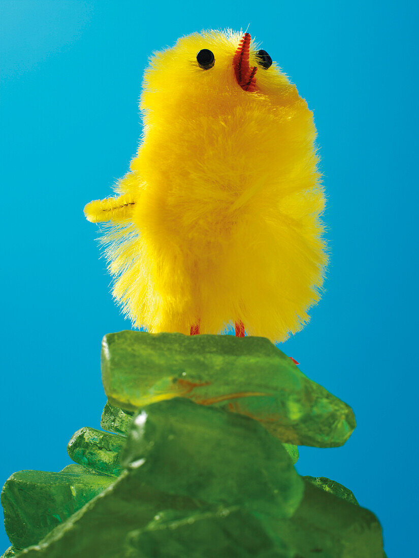 Yellow Easter Chick Standing on a Pile of Green Glass Stones