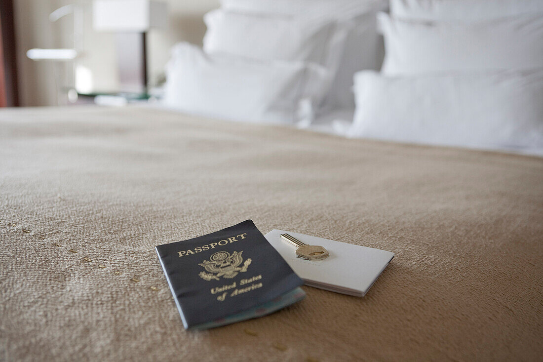 Schlüssel und Reisepass auf dem Bett im Hotelzimmer, Barcelona, Spanien
