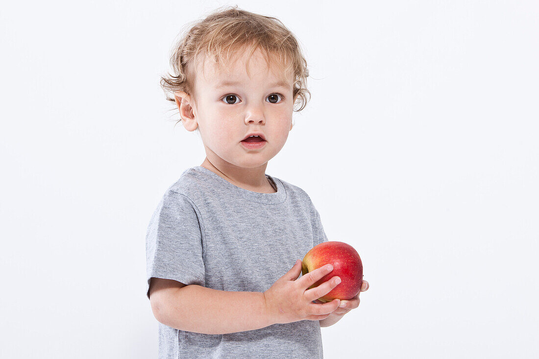 Junge hält Apfel