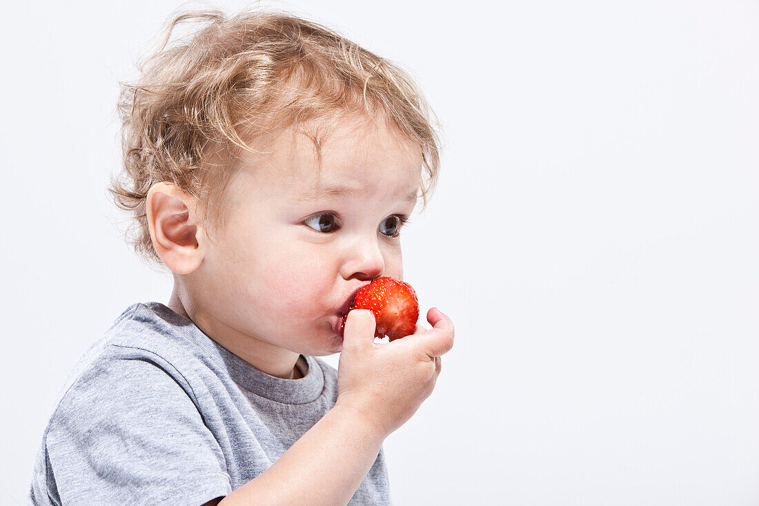 Junge isst Erdbeere