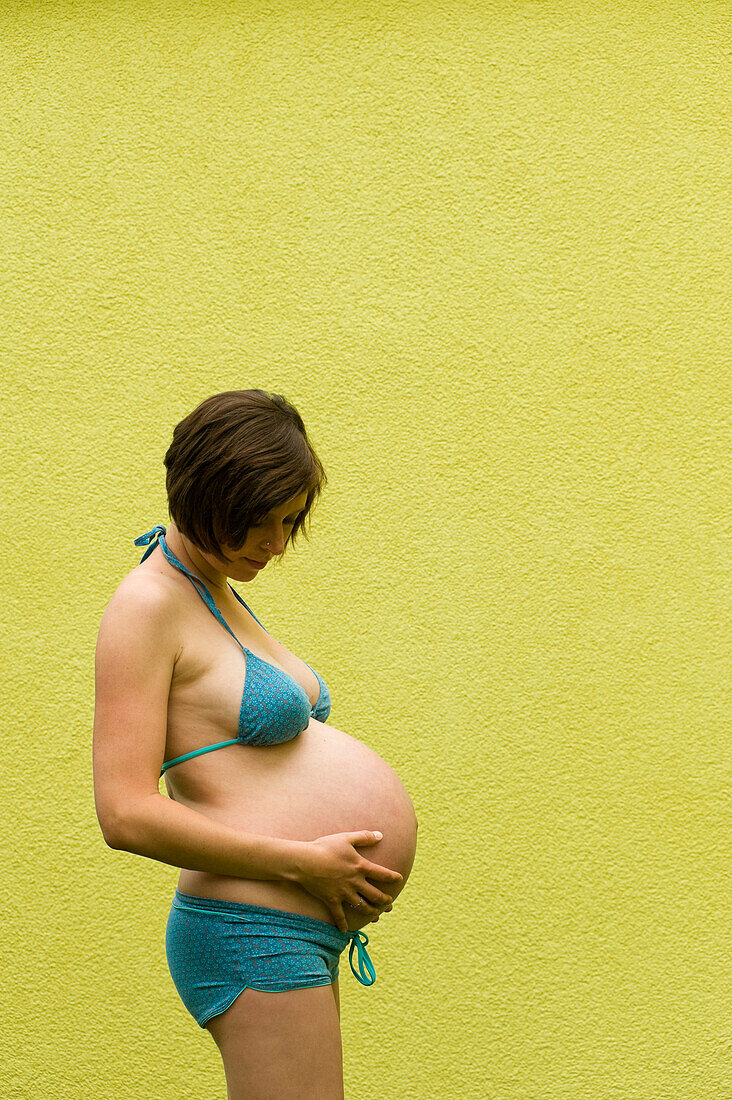 Profile of Woman, Nine Months Pregnant, Touching Her Belly