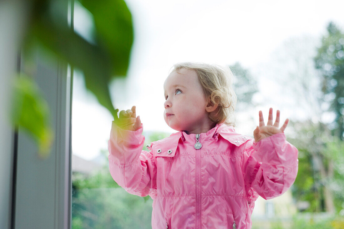 Kleines Mädchen am Fenster stehend