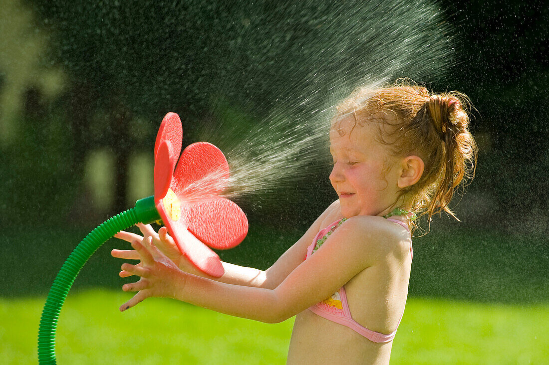 Girl Playing with Flower Sprinkler, Salzburg, Austria