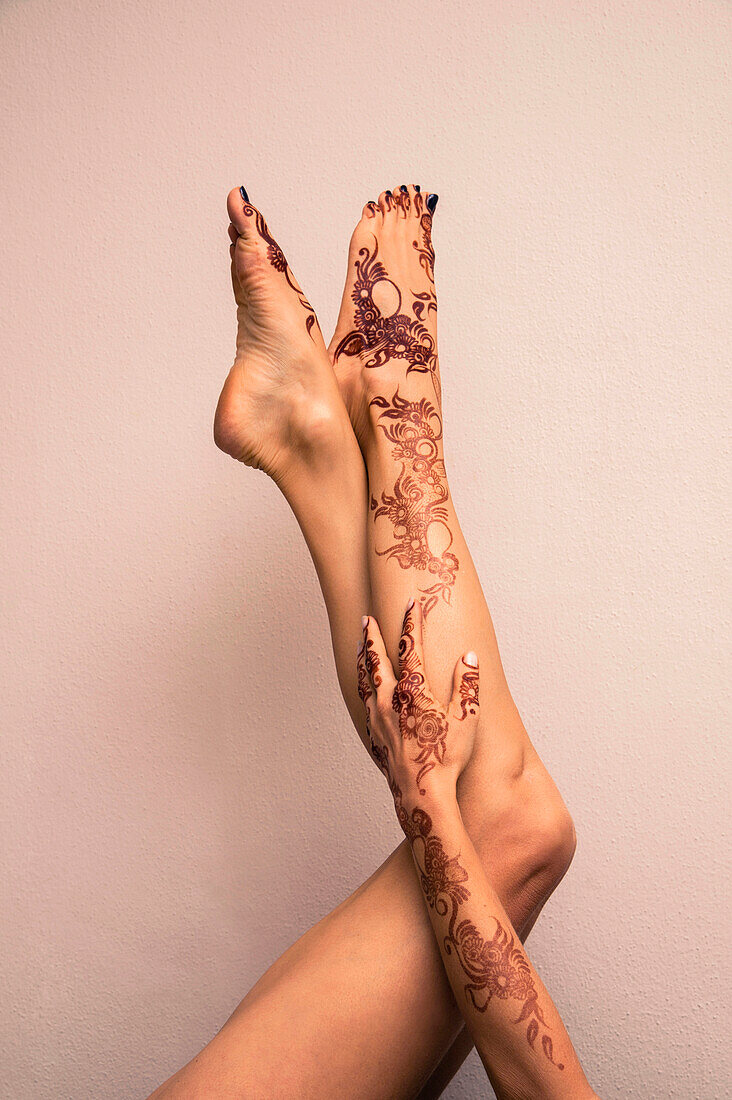 Woman's Legs and Arm Painted with Henna in Arabic Style, Studio Shot