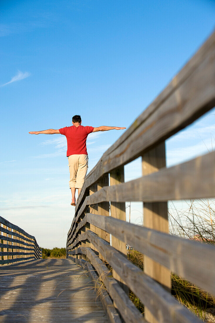 Man Balancing on Wooden Railing, Honeymoon Island, Florida, USA