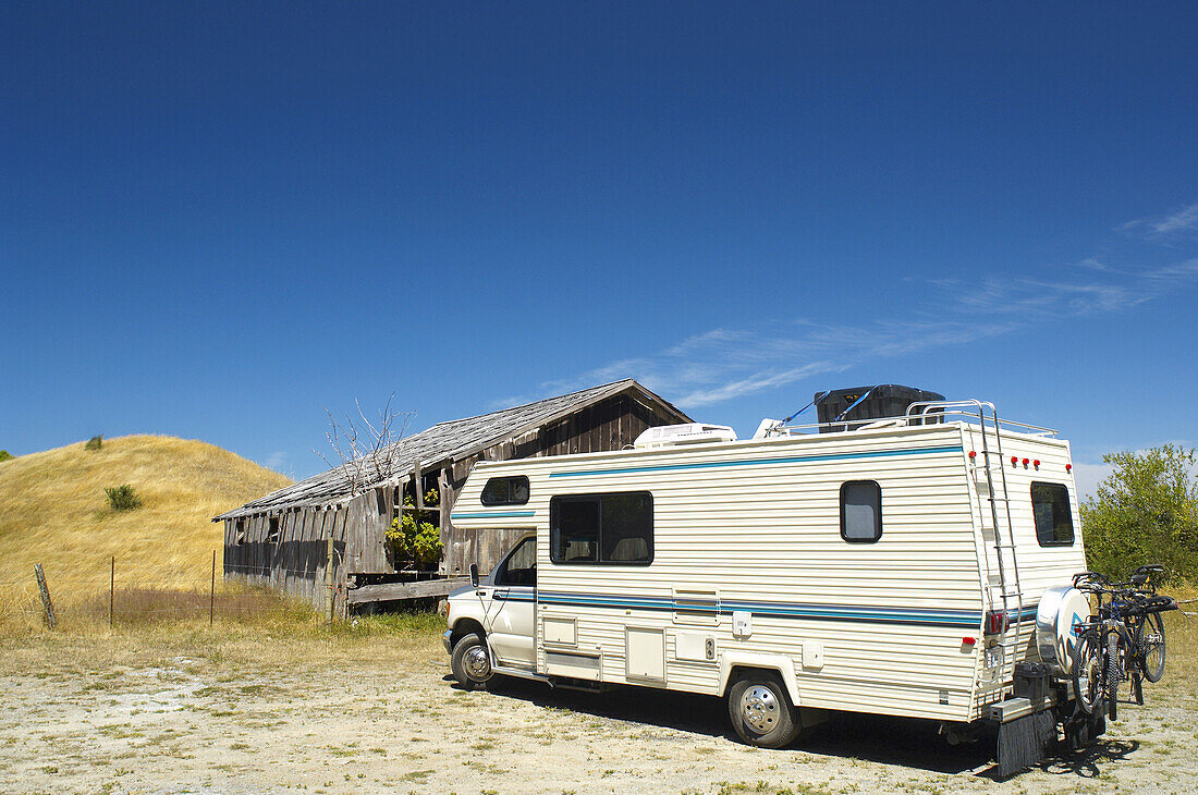 Recreational Vehicle Parked by Abandoned Building