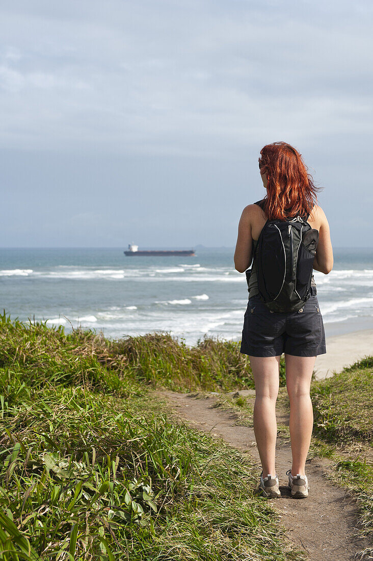 Rückenansicht einer wandernden Frau mit Blick auf die Aussicht, Ilha do Mel, Parana, Brasilien
