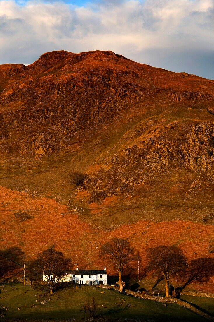 Ansicht von Rocky Hill mit Landhaus bei Sonnenuntergang; Cumbria, England, UK