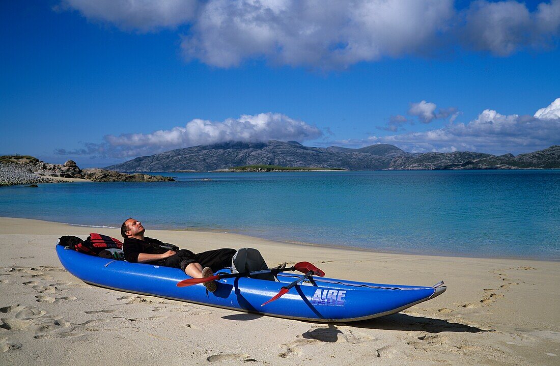 Mann entspannt sich im Kanu; Island Of Scarp, Insel Harris, Schottland, UK