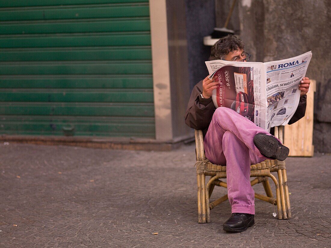 Mann beim Zeitungslesen; Neapel, Italien