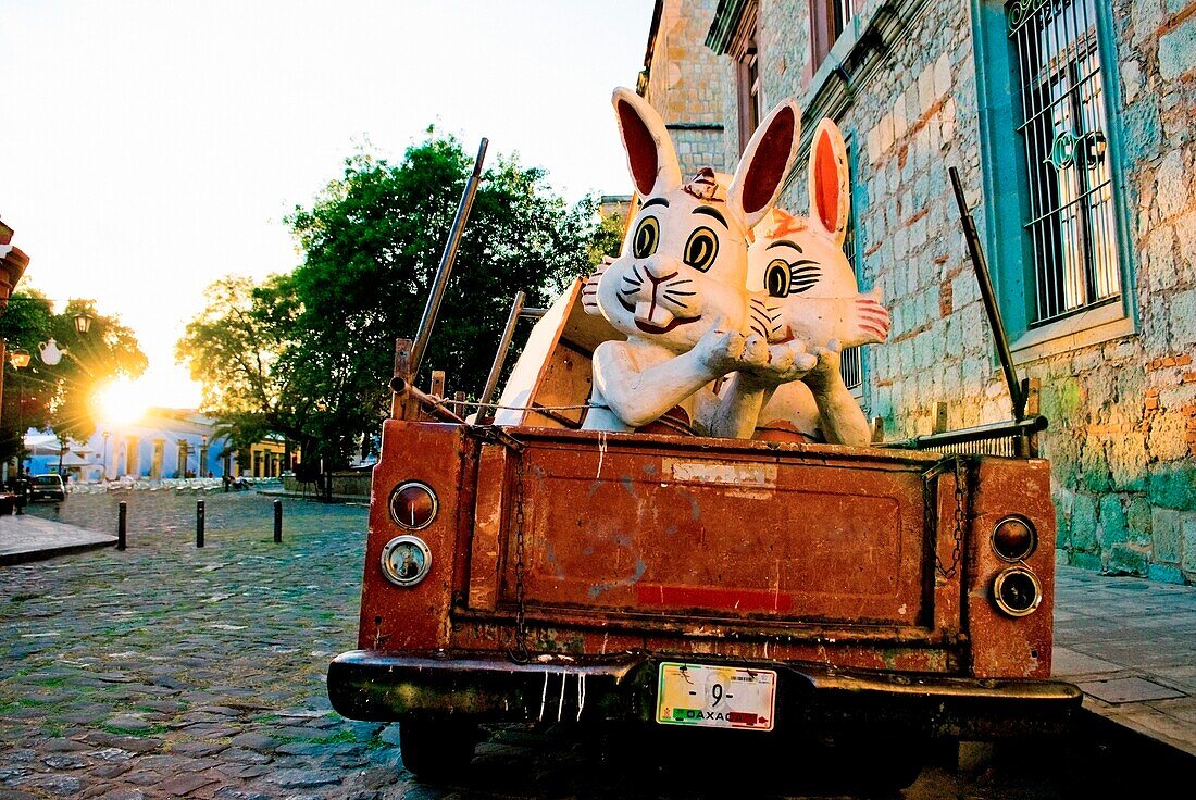 Altes Auto mit Kitschfiguren von Kaninchen auf der Straße; Mexiko