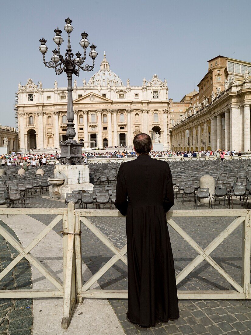 Rückansicht eines Priesters, der den Petersplatz beobachtet; Rom, Italien