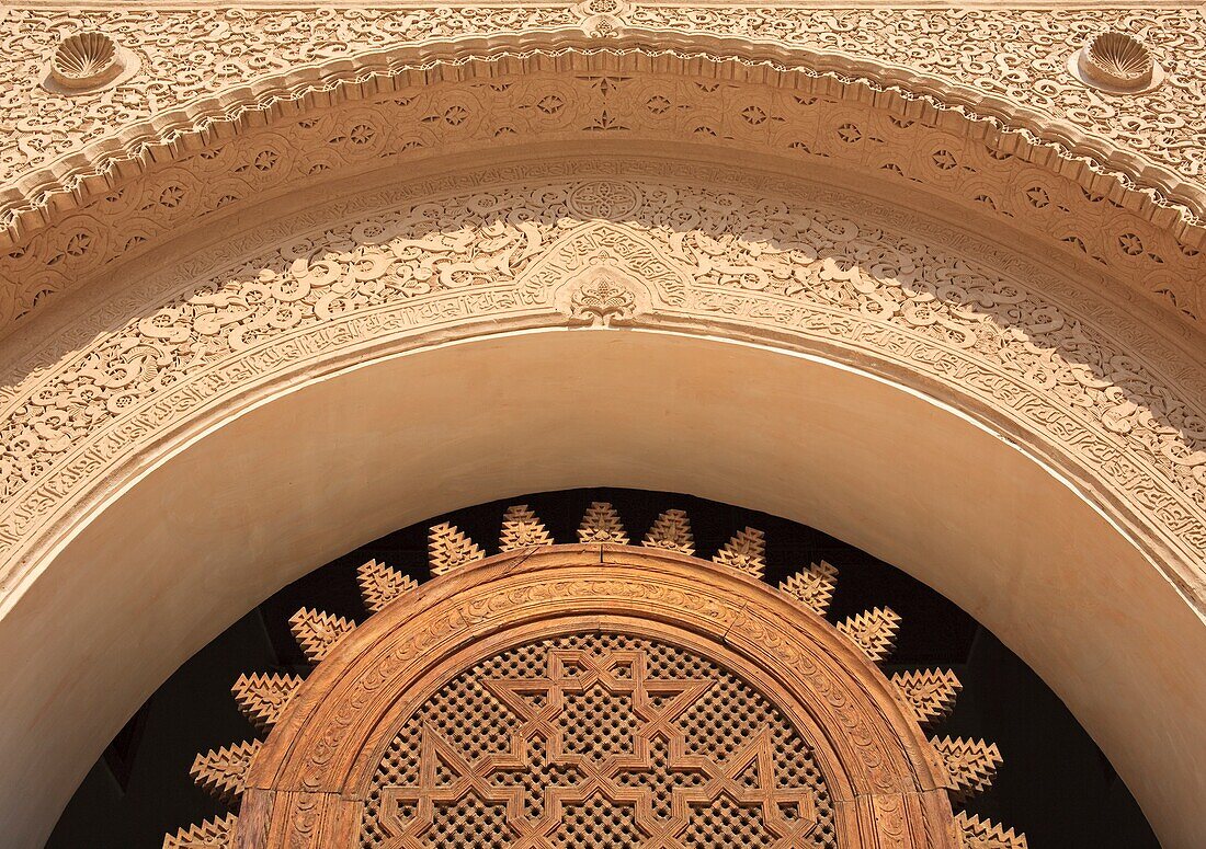 Detail eines Holzgitters und Stuckarbeiten an der Tür der Ali Ben Youssef Medersa; Marrakesch, Marokko