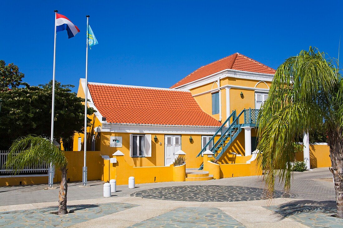 Building Exterior With Flags Weaving Outside; Monuments Office Of Aruba, Oranjestad, Aruba Island, Kingdom Of The Netherlands