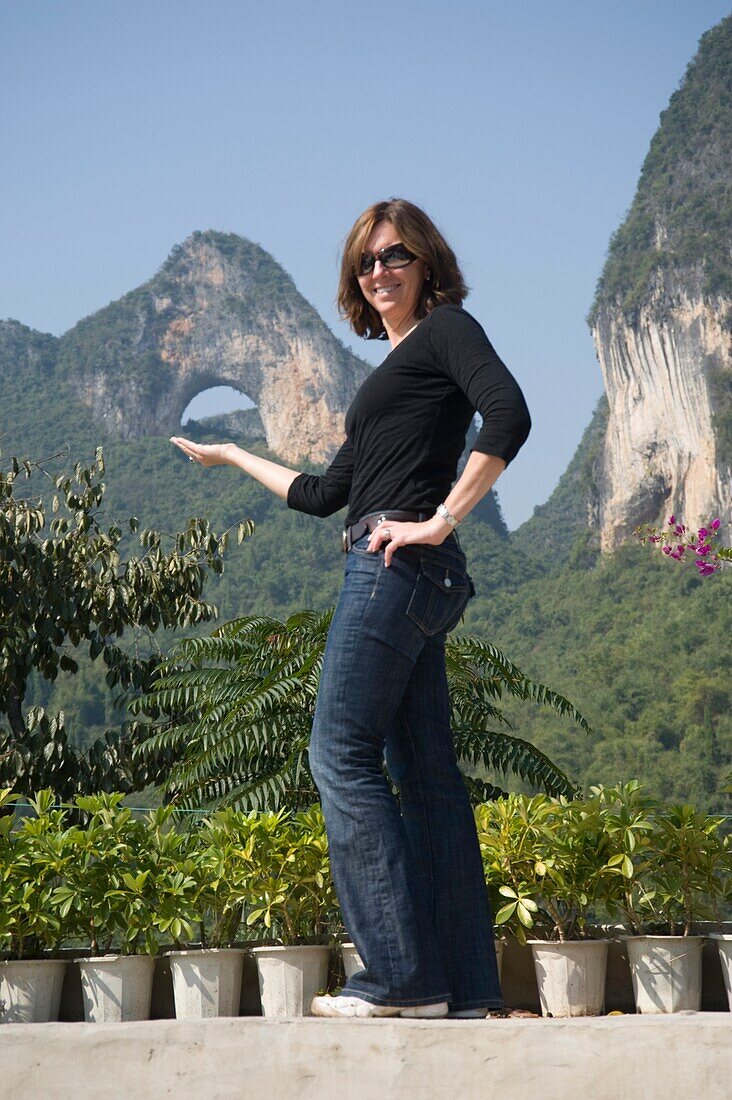 Moon Hill, Yangshuo, China; Woman Posing In Front Of Mountain