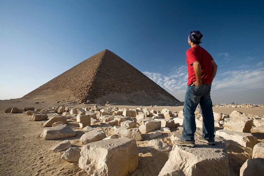 Ein Mann, der in der Nähe einer Pyramide in der Wüste steht; Ägypten, Afrika