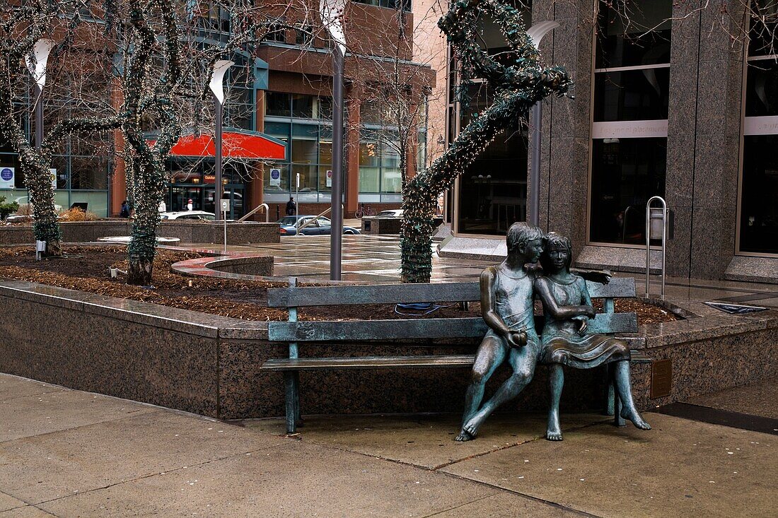 A Statue Of A Couple Sitting On A Bench