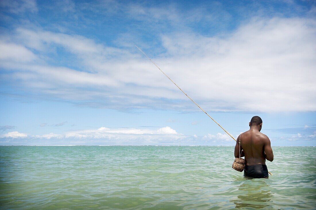 Fischer watet in den Ozean, Brasilien