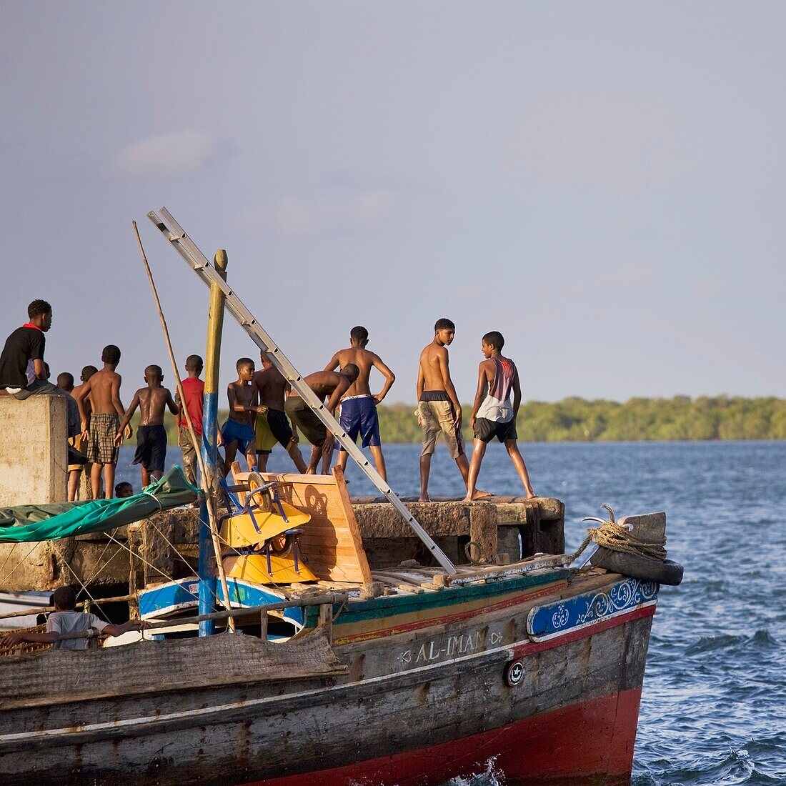 Young Boys Jumping Into The Sea By The Jetty At Lamu, Kenya, East Africa