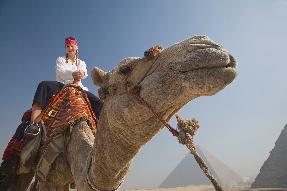 Junge Touristin auf einem Kamel bei den Pyramiden von Gizeh; Kairo, Ägypten, Afrika