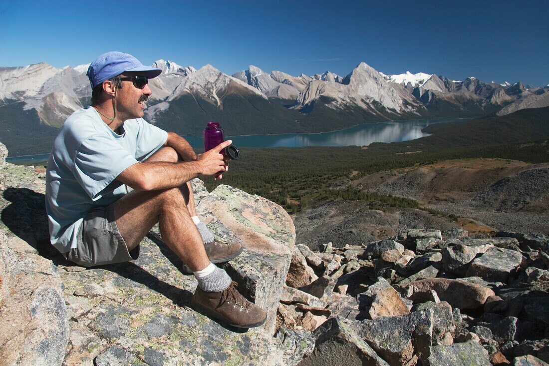 Männlicher Wanderer, der sich mit einer Wasserflasche ausruht, Jasper National Park, Alberta, Kanada