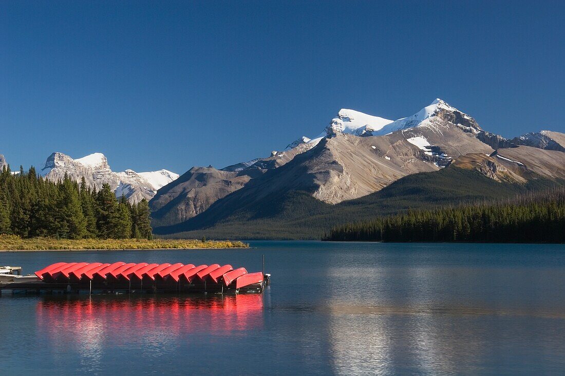 Jasper National Park, Alberta, Canada; Canoes And A Dock And Mountains In Maligne Lake