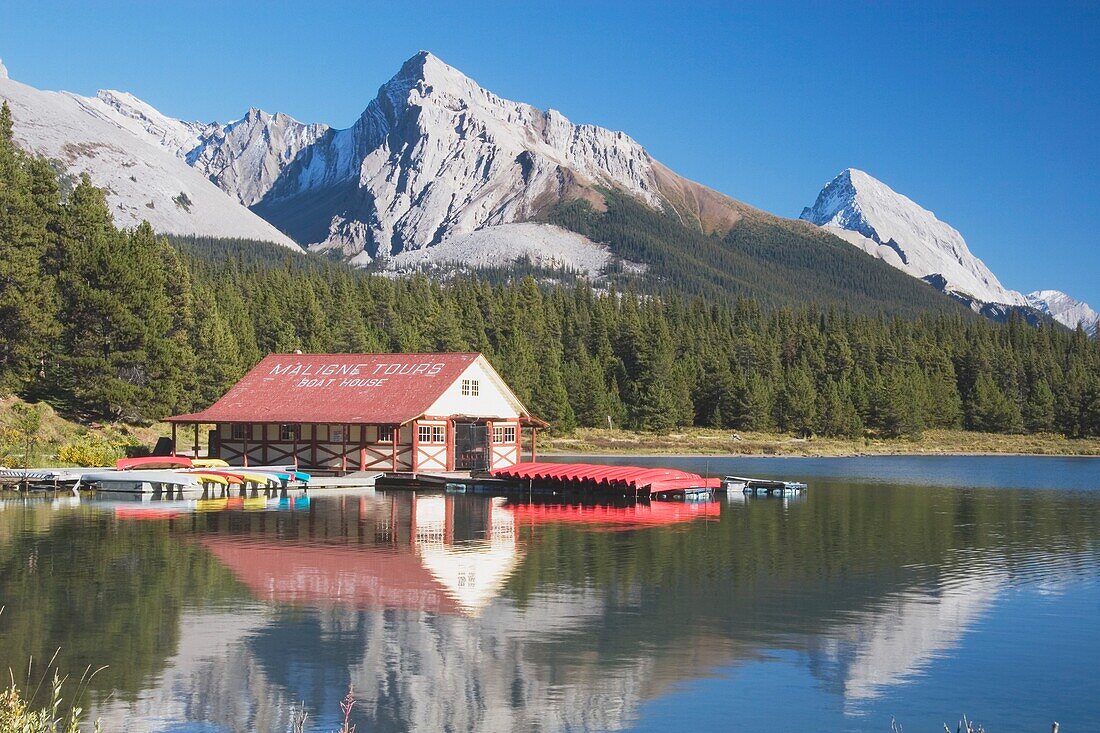 Jasper National Park, Alberta, Canada; Canoes On A Dock On Maligne Lake With Mountains In The Background