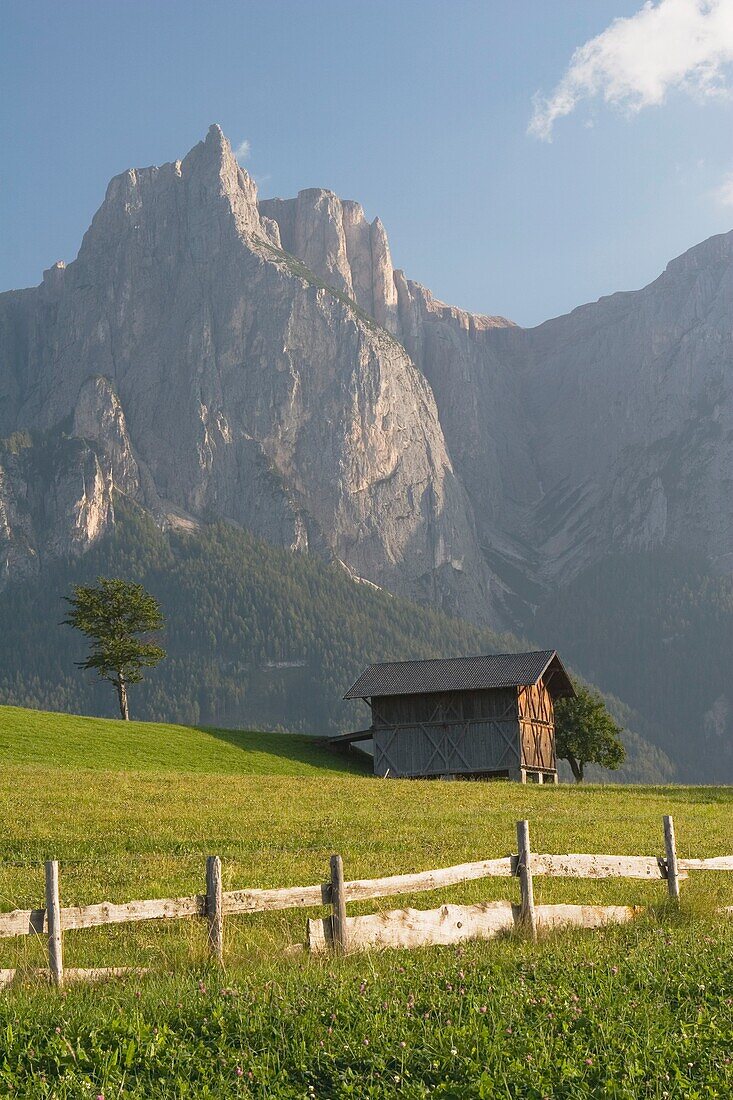 Castelrotto, Alto Adige, Italy; Fence And Barn In Meadow With Mountains In The Background
