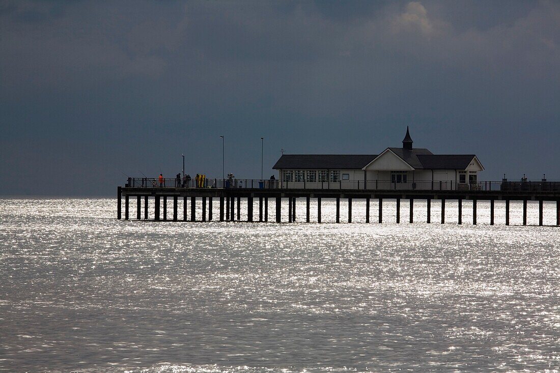Southwold, Suffolk, England; Fischer, die auf einem Pier und einem Gebäude entlang der Nordseeküste stehen