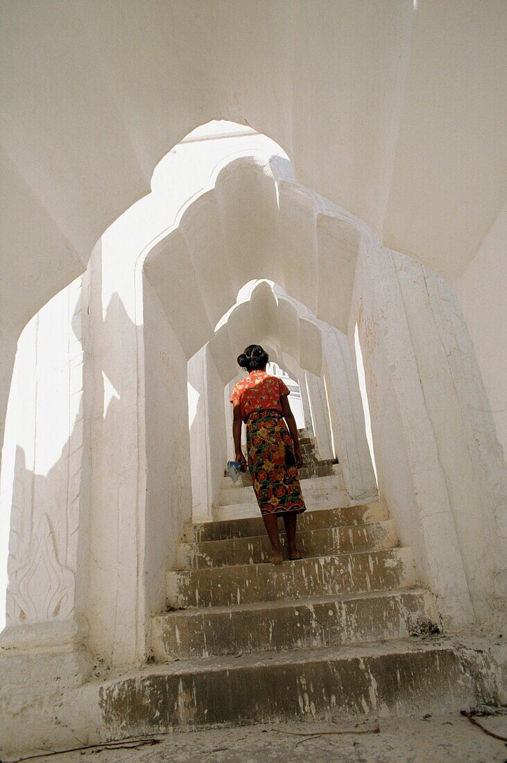 Woman Walking Up Steps In Covered Alleyway