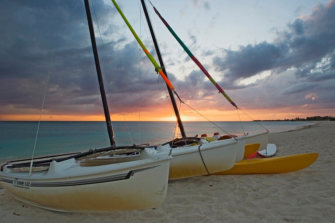 Sonnenuntergang am Strand Playa Ancon bei Trinidad mit gestrandeten Segelbooten im Vordergrund.