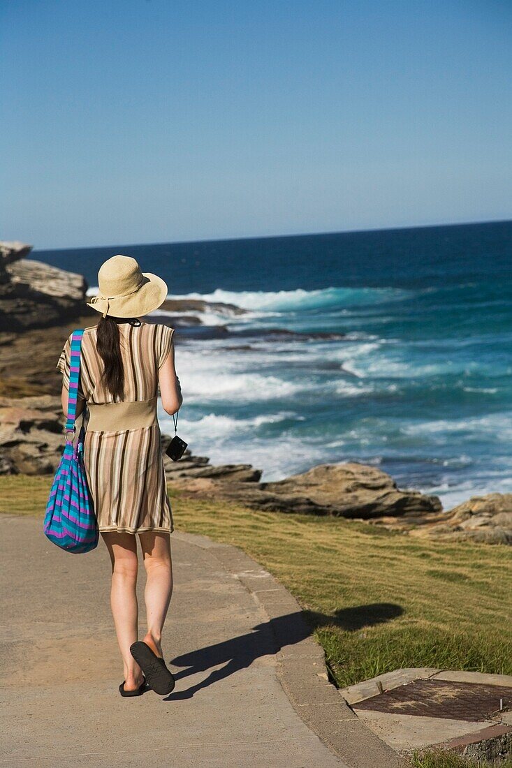 Frau geht zwischen Bondi Beach und Bronte Beach spazieren