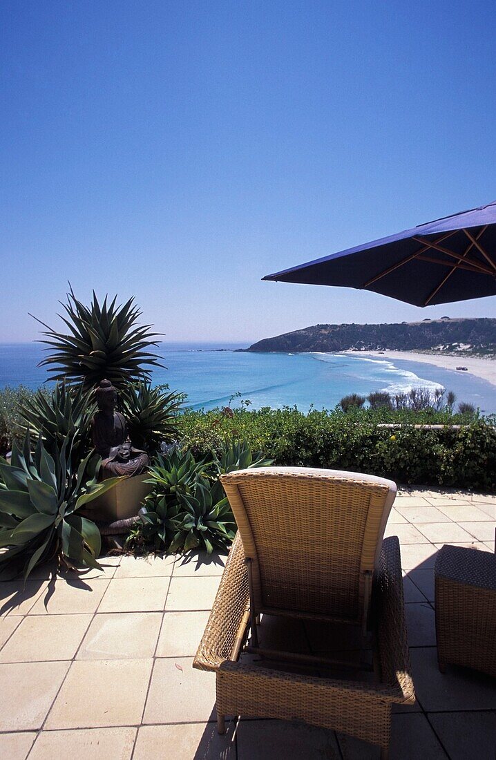 Leere Sonnenliege auf einer Terrasse mit Blick auf das Meer