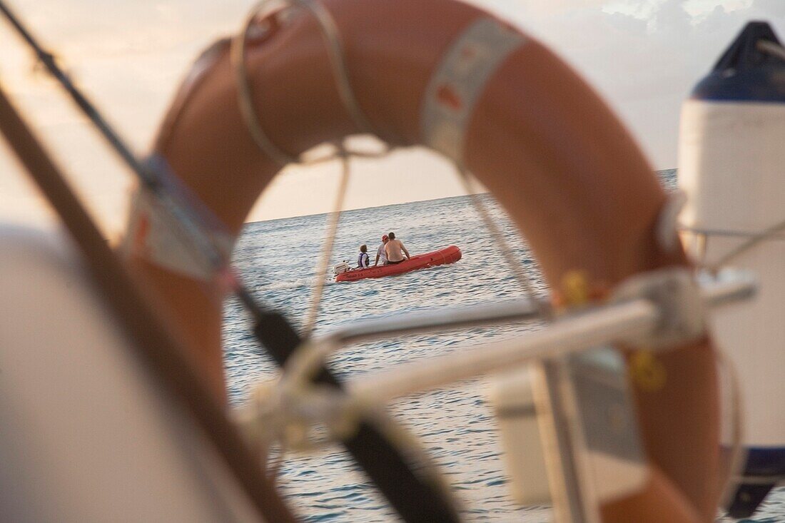 Junge und Männer in Boot durch Rettungsring gesehen