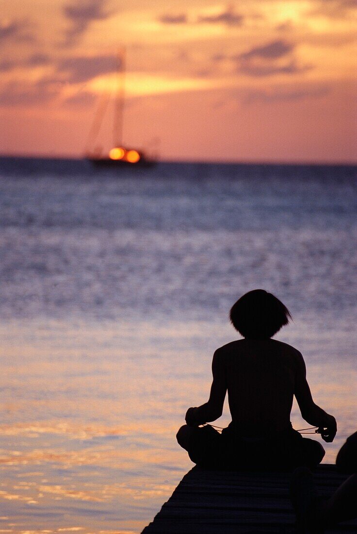 Mann in Silhouette am Ende eines Piers stehend