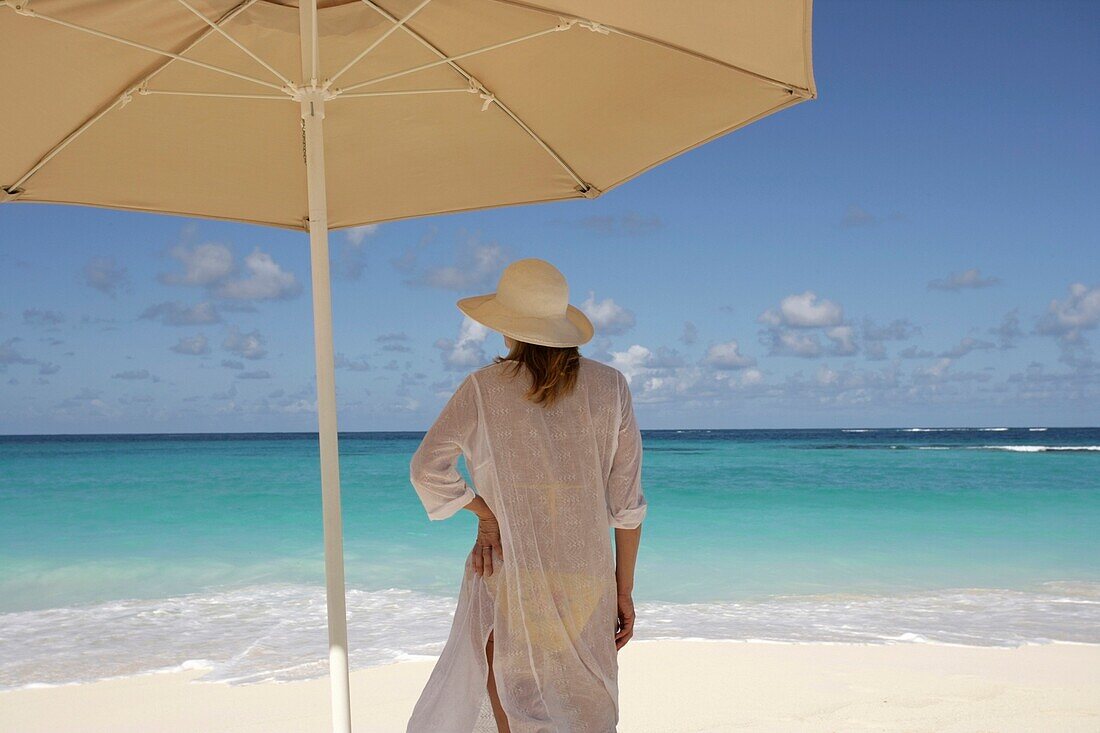 Woman On A Tropical Beach Under An Umbrella