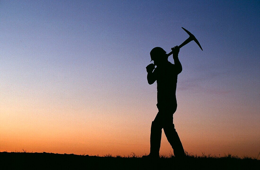 Miner In Silhouette With Pick