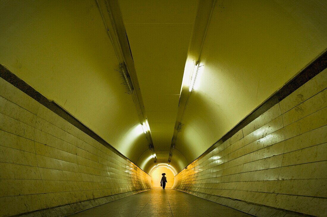 Woman With Bag On Head Walking Through Pedestrian Tunnel