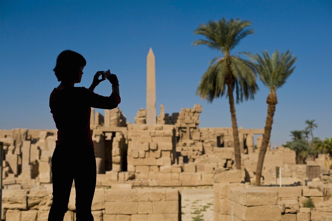 Silhouette einer Frau, die die Ruinen des Karnak-Tempels fotografiert