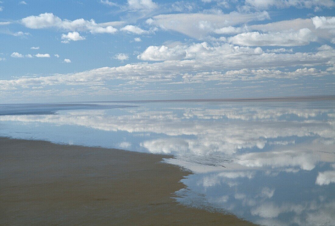 Himmel mit Wolken, die sich auf ruhigem Wasser spiegeln