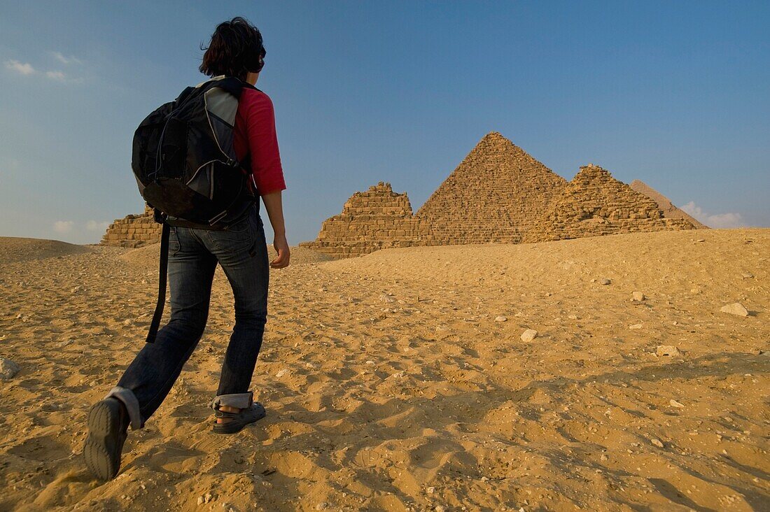 Frau mit Rucksack auf dem Weg zu den Pyramiden in der Abenddämmerung