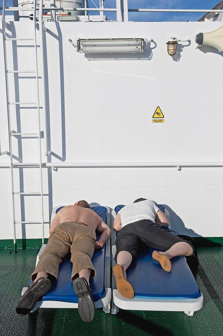 Kreuzfahrtschiff-Passagiere an Bord des Schiffes schlafen auf dem Deck