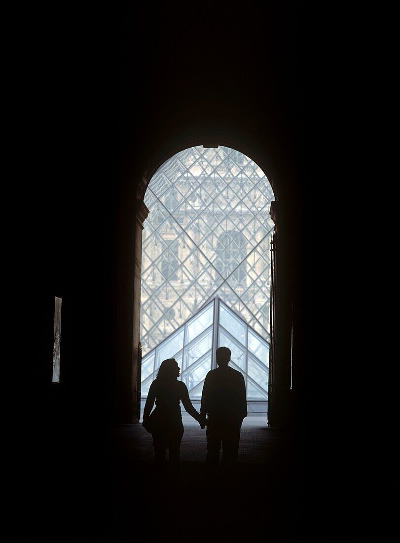 Paar geht durch die Passage Richelieu zur Louvre-Pyramide