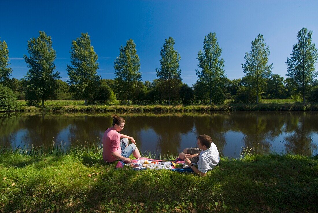 Ehepaar beim Picknick am Ufer des Nantes-Brest-Kanals