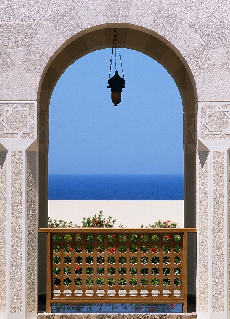 Blick durch einen Torbogen auf Strand und Meer