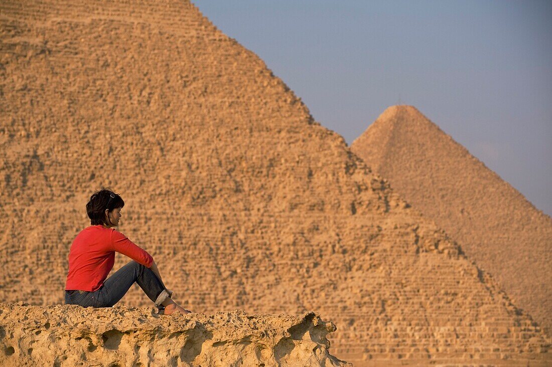 Frau auf felsigem Gelände mit Blick auf die Pyramiden
