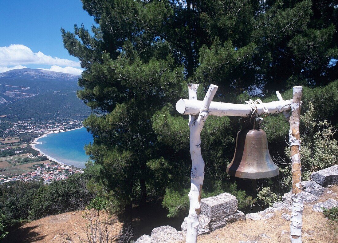 Messingglocke, die an einer Holzkonstruktion hängt, Blick auf die Küstenlinie im Hintergrund