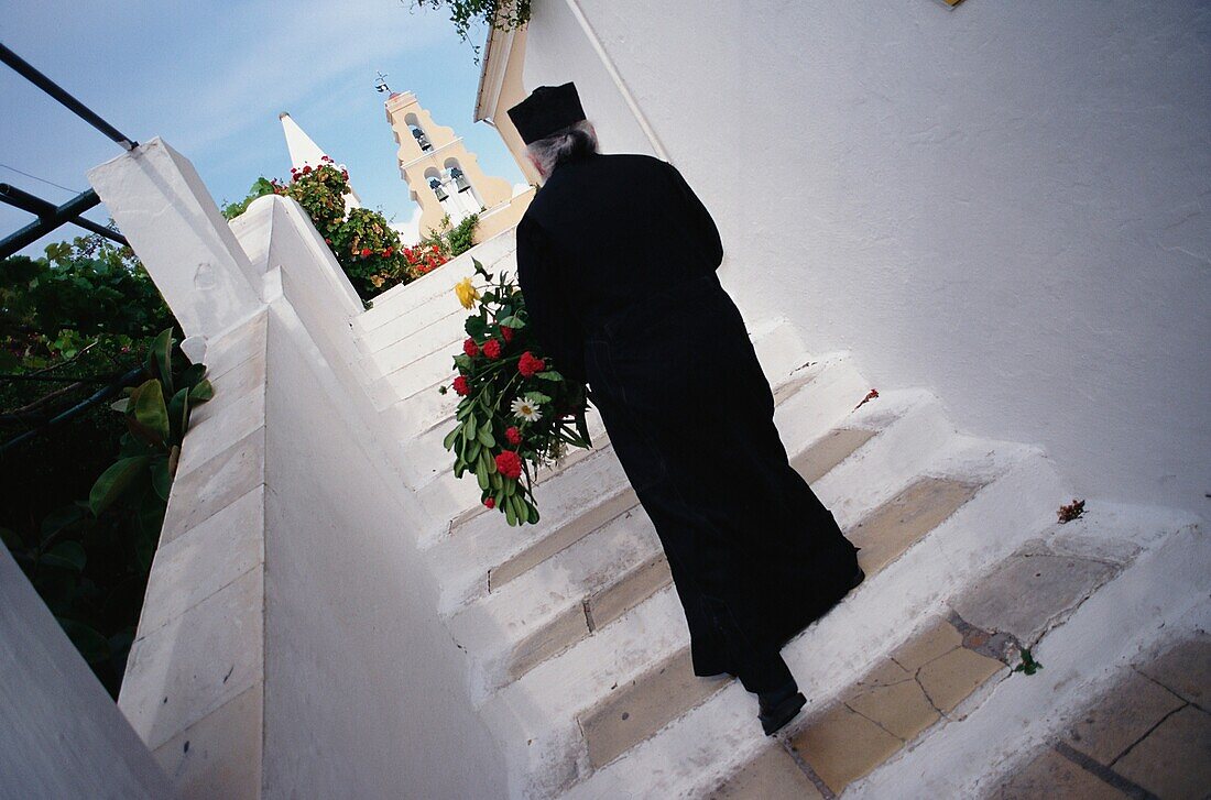 Orthodoxer Priester geht die Treppe hinauf, Korfu